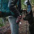 Load image into Gallery viewer, Scout & About Deluxe Training Pouch - Original Mocha Print on human's waist giving treats to black dog on trail
